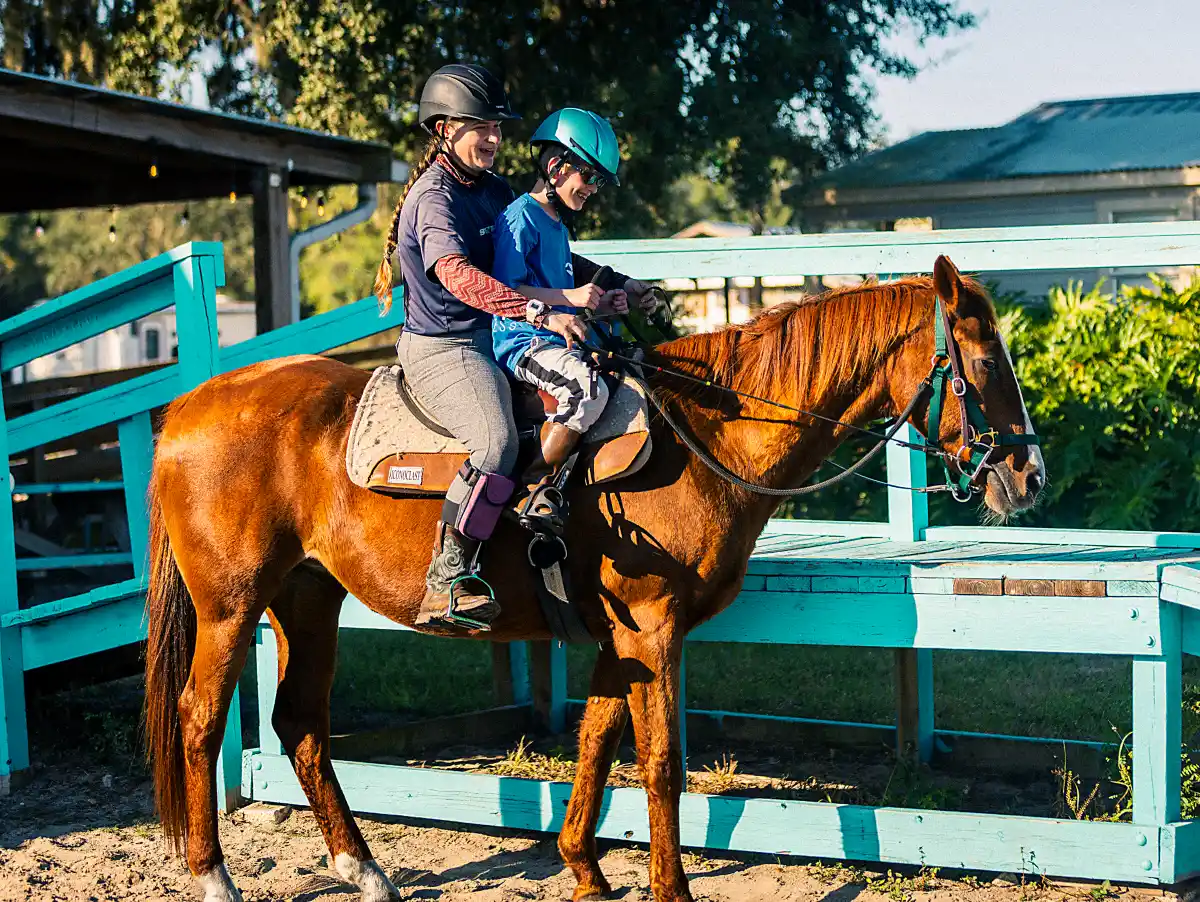 Child with special needs building confidence during adaptive horseback riding session